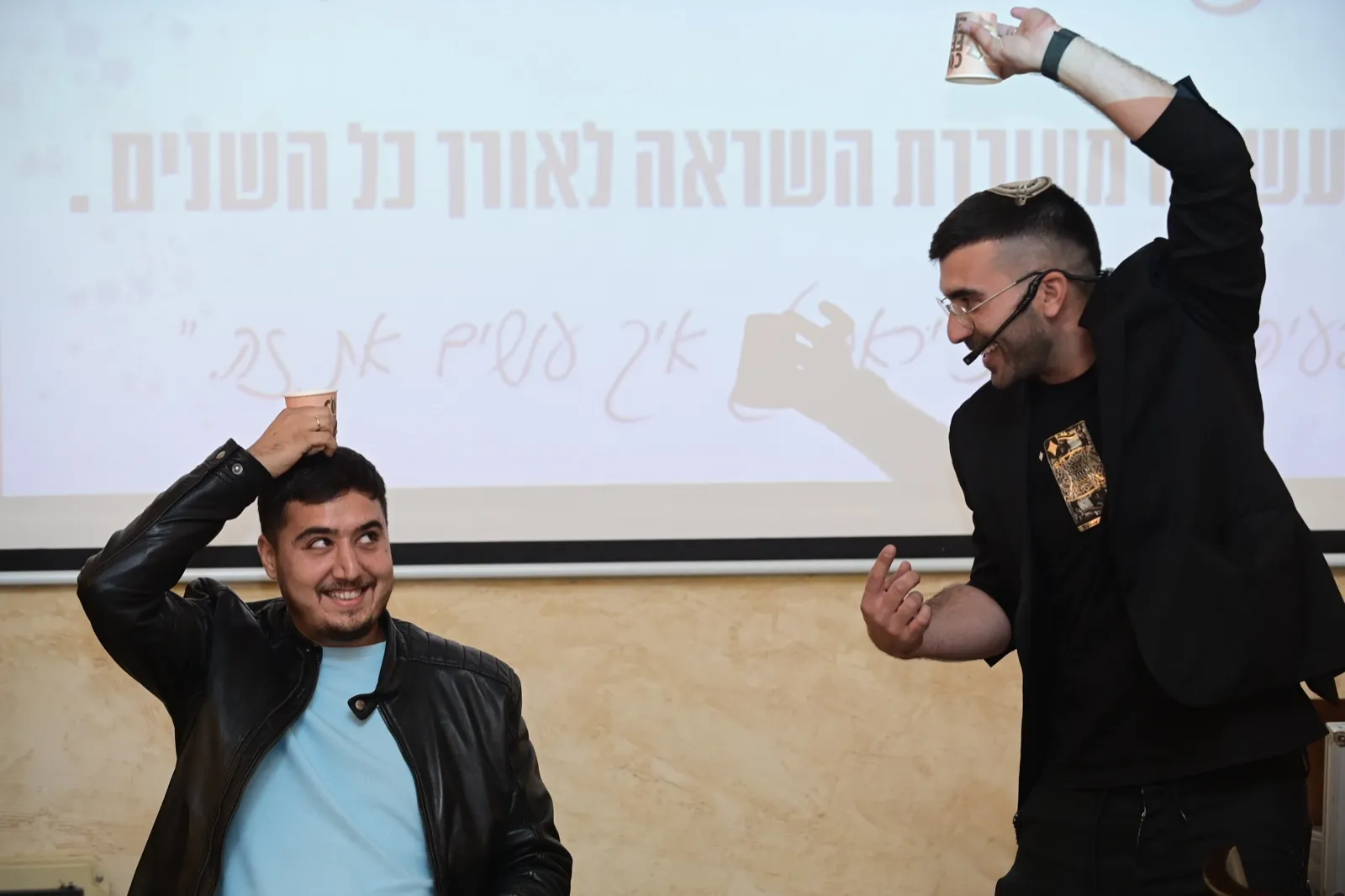 עומרי ביטון על הבמה עם מתנדב מהקהל